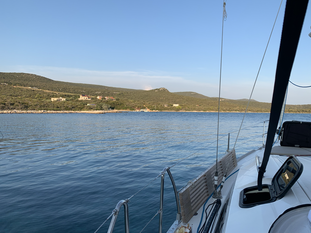 Yacht vor Anker an grüner Küste